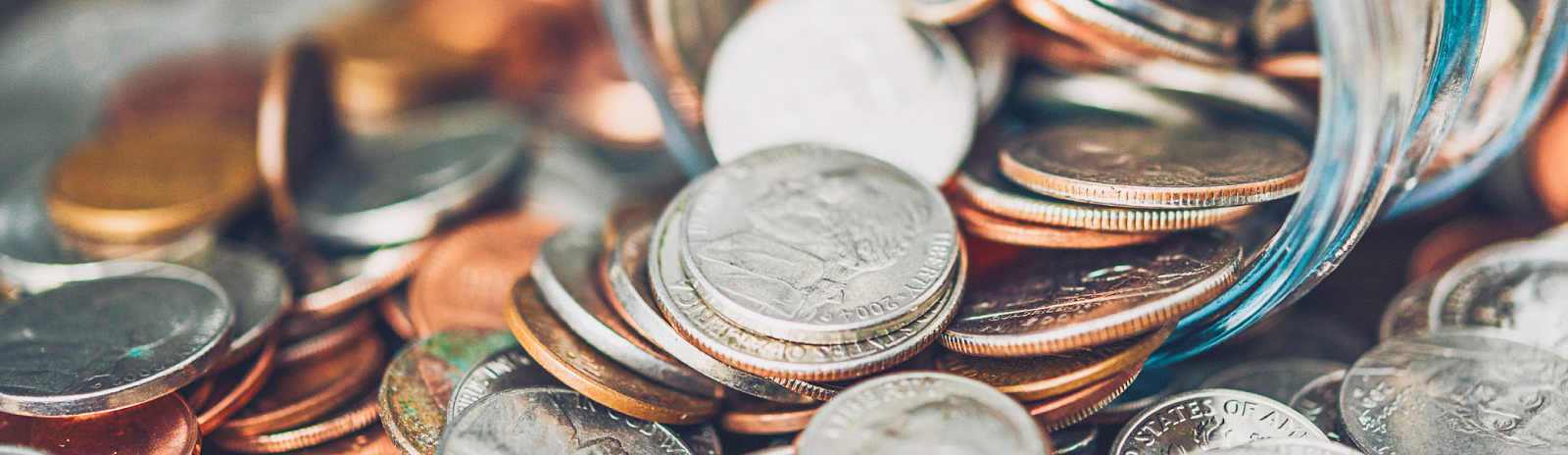 various coins spilling out of a jar