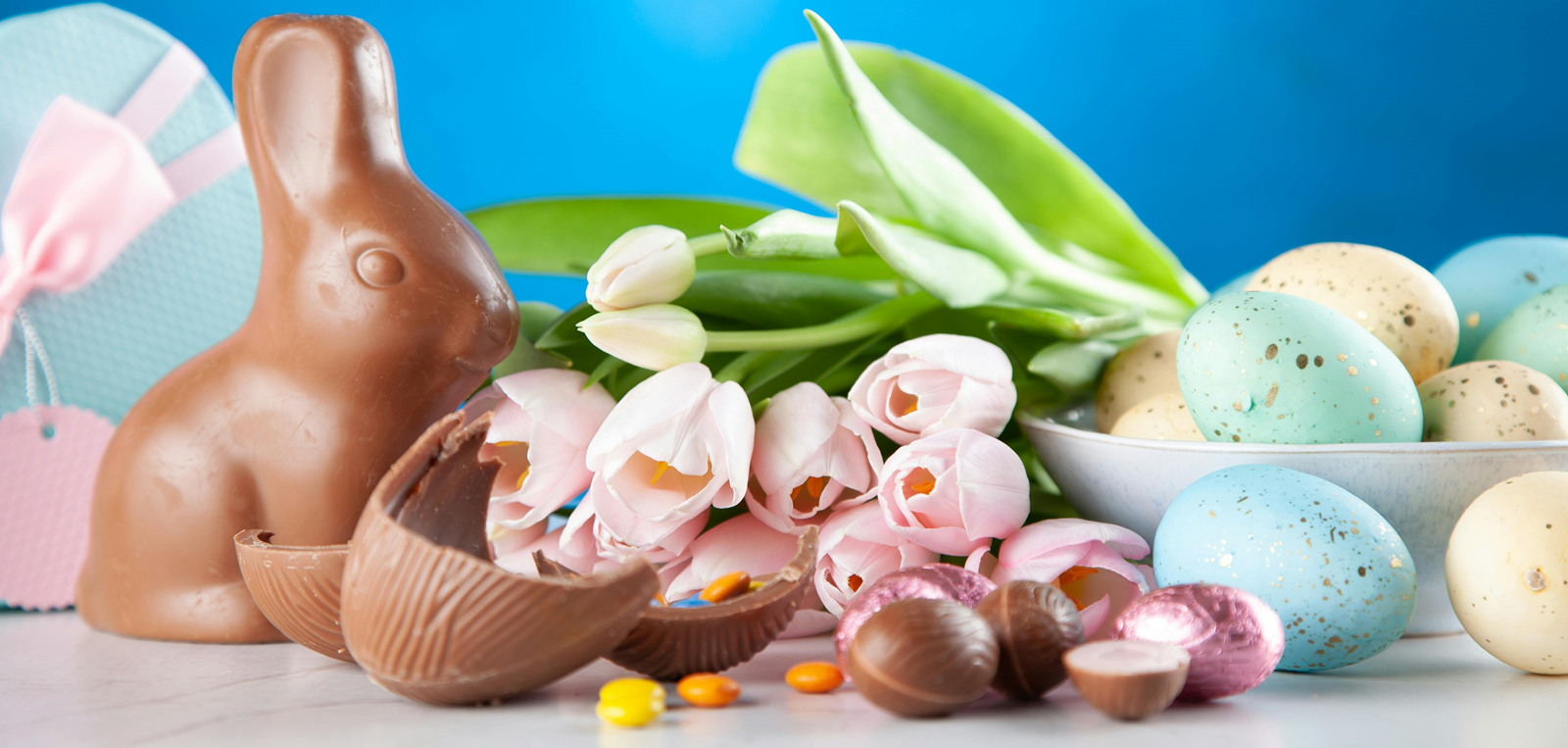 A chocolate bunny and other easter candies on a white table