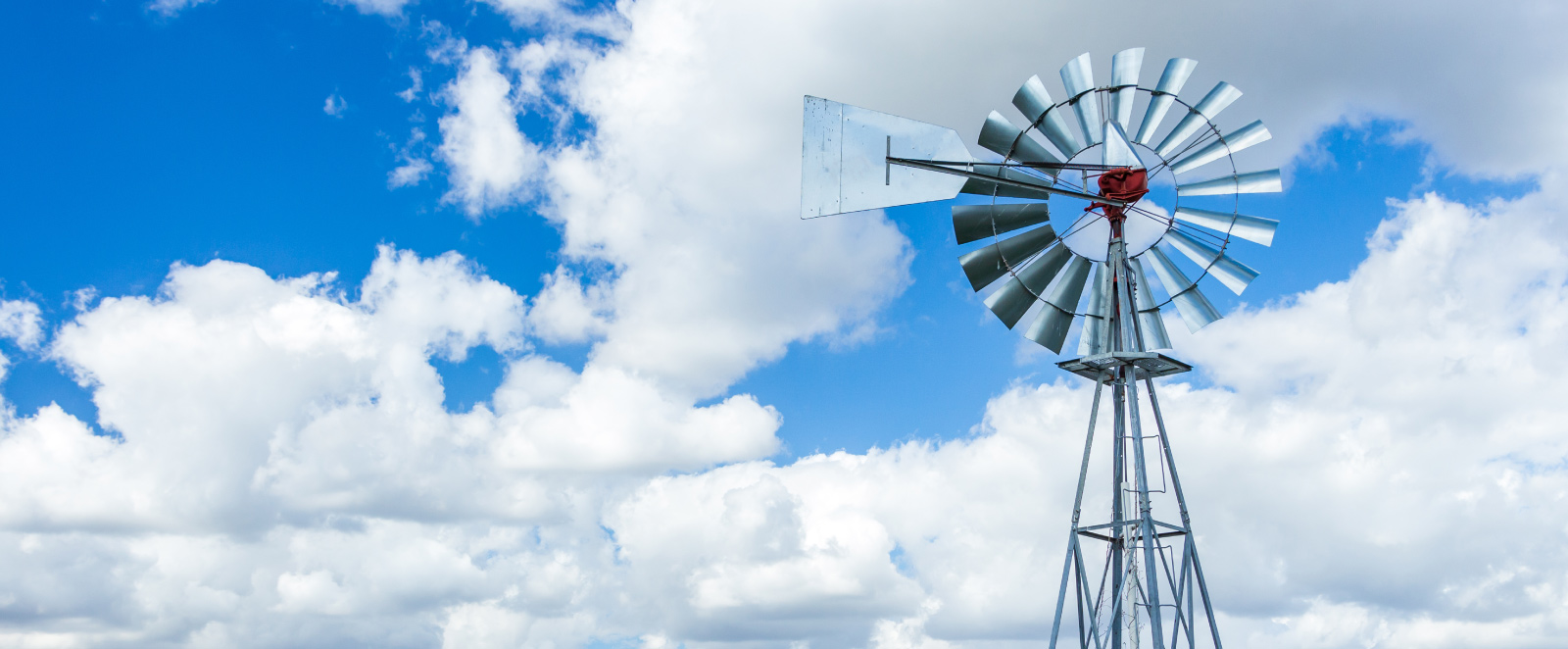 Windmill in front of blue, cloudy skies