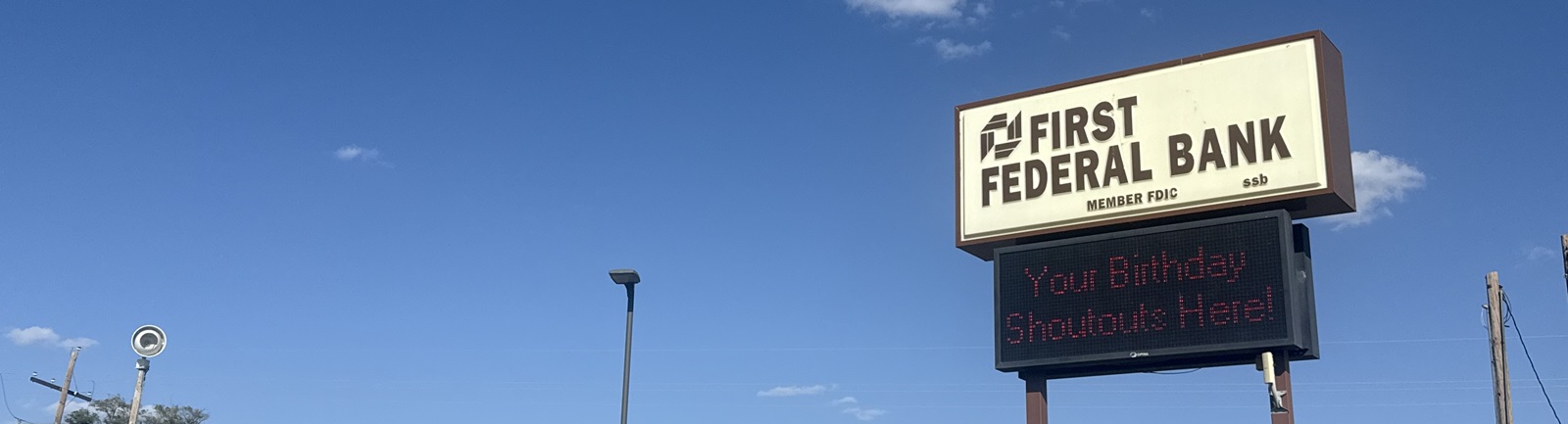 Image of a digital sign that says "Your Birthday Shoutouts Here!" against a blue sky